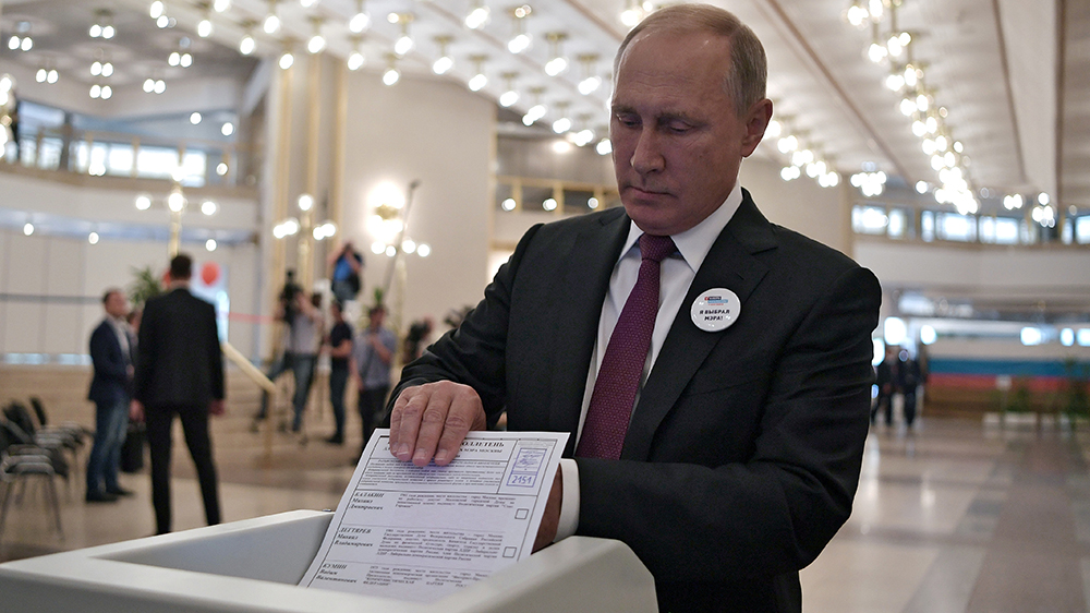 En middelaldrende mann leverer sin stemmeseddel. Foto. 