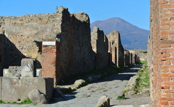 Pompeii, utgravningsområde med bygninger, vei og vulkanen Vesuv i bakgrunnen
