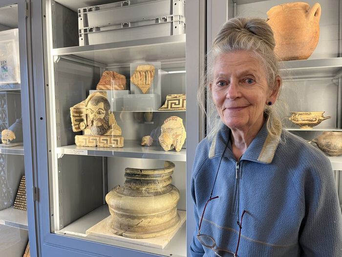 Kvinne foran antikke rester på museum