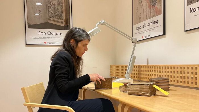 Karin Kukkonen engaged in old books at the university's library.