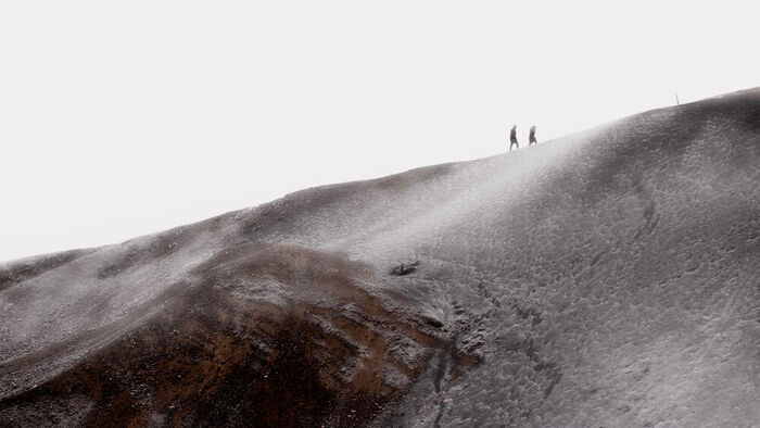 Two people climbing the old slag mounds from the copper mines in Røros.