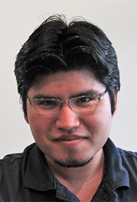 portrait photo, young man, black short hair and beard, glasses on, dark shirt 