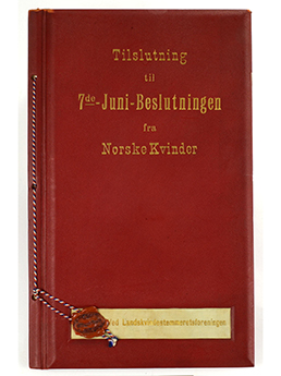 Foto av en rød bok med gullskrift. Det står: Tilslutning til 7de.juni-beslutningen fra niorske kvinner. 