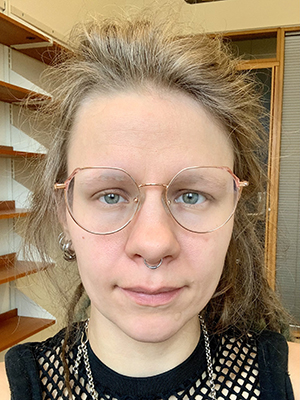 Portrettfotografi av en kvinne med blondt hår og briller