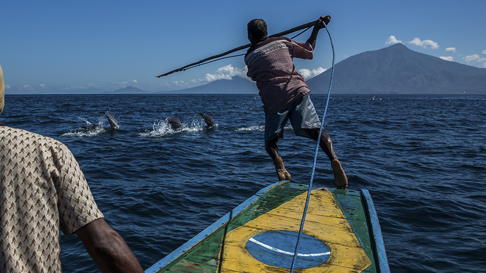 Mann med harpun på båt jakter hval.