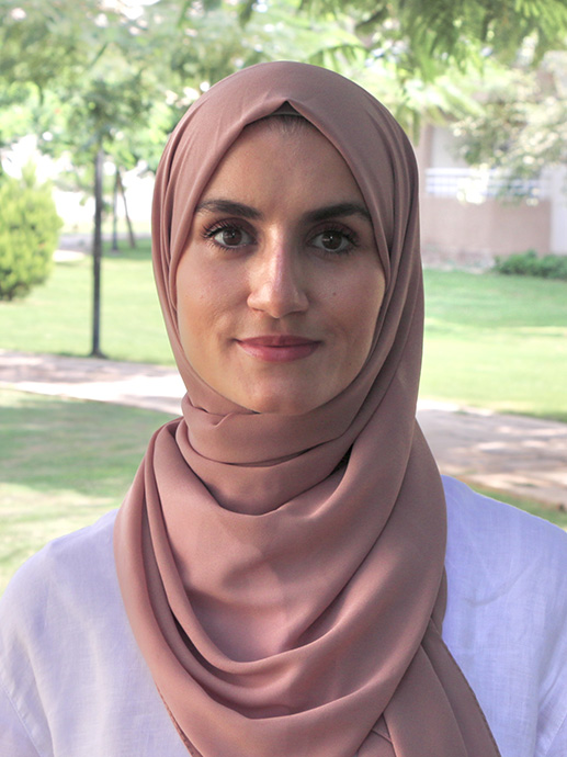 Portrait of Laila Makboul, serious-looking woman wearing pink headscarf.