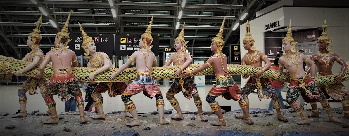 Skulptur med ni thailandske dukker i bar overkropp - på størrelse med mennesker, som holder en lang og tykk metallslange.