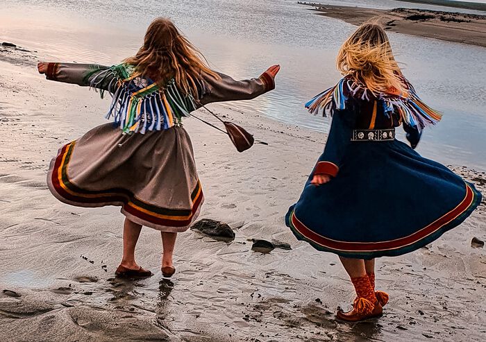 Two girls in kofte, dancing. Photo