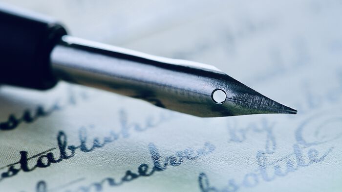 illustration photo of a quill pen with a handwritten letter