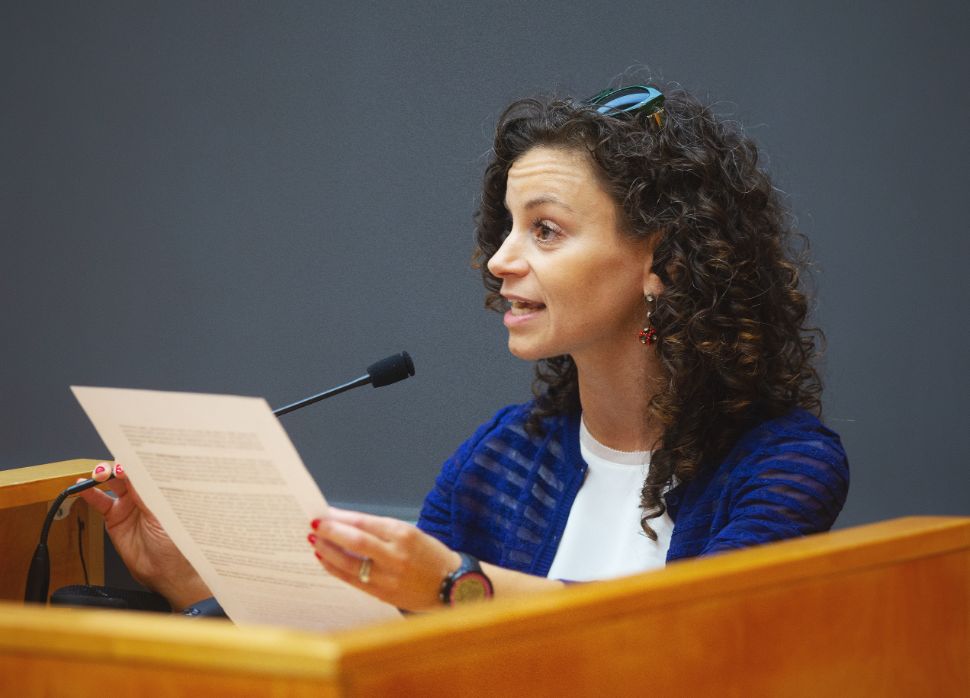 Kellie Gonçalves speaking at the podium