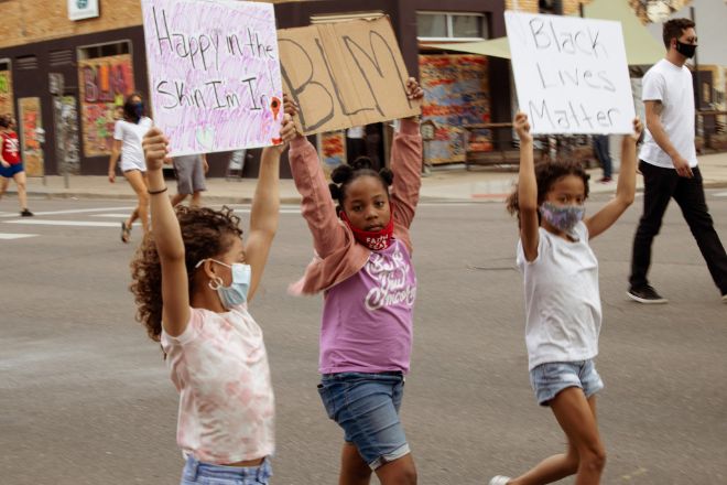 Tre unge jenter med munnbind går i demonstrasjonstog for Black Lives Matter