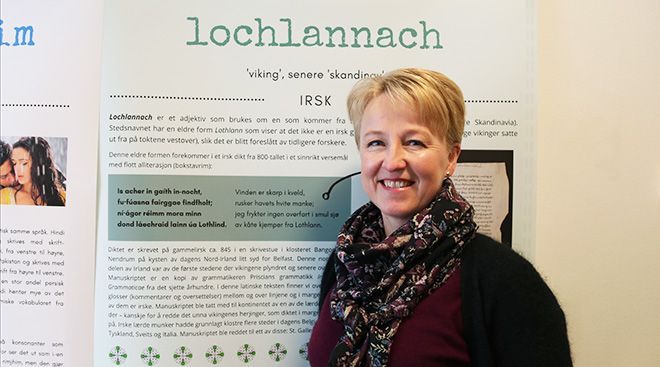 Kristin Bech foran en plakat med påskriften «Lochlannach».