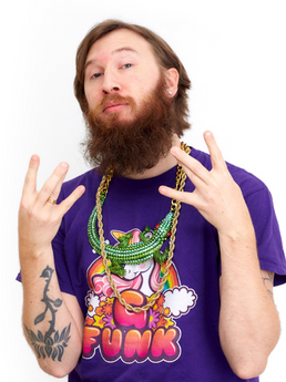 Mann med skjegg og smykker, som gjør rap-tegn med hendene. Foto.