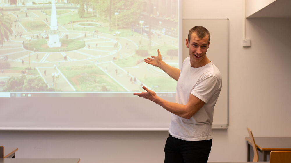 En ung mann foran et lerret med en presentasjon.